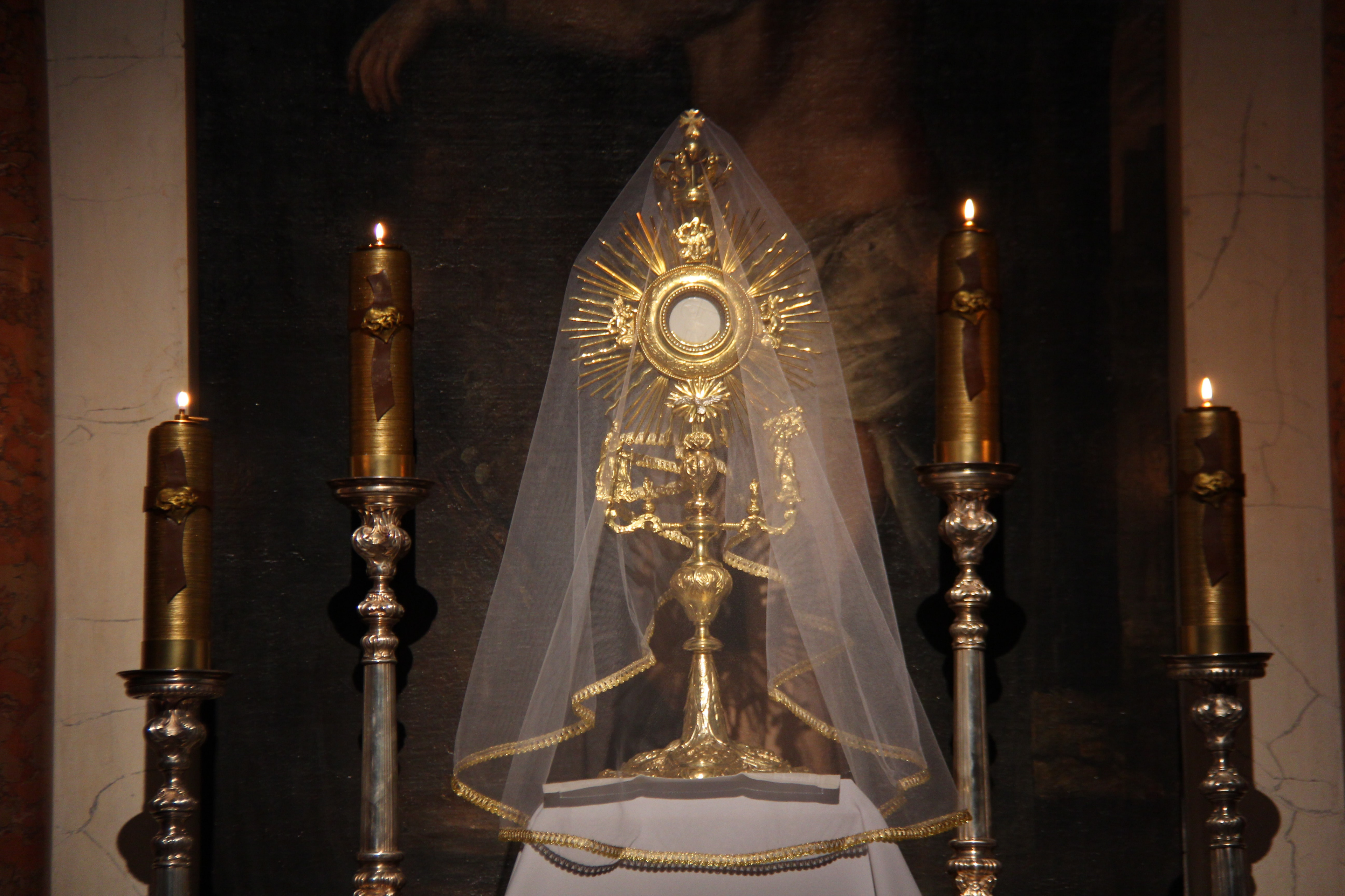 A veiled monstrance with the Blessed Sacrament exposed.
