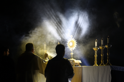 Two men praying before Jesus in the Blessed Sacrament.