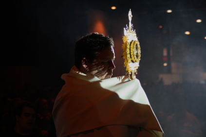 A priest raises the Blessed Sacrament for Benediction.